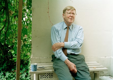 Alan Bennett sits on a bench with a drinks mug