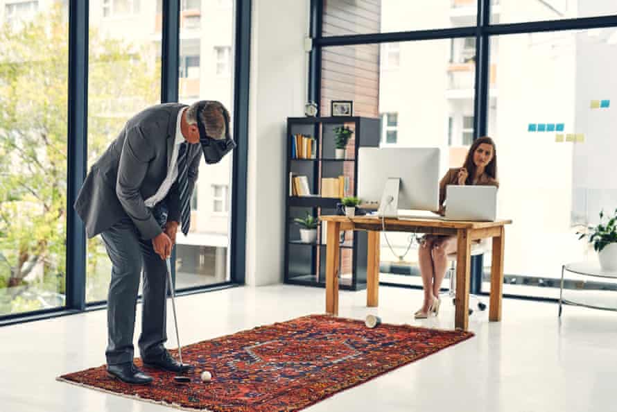 A man playing golf in an office