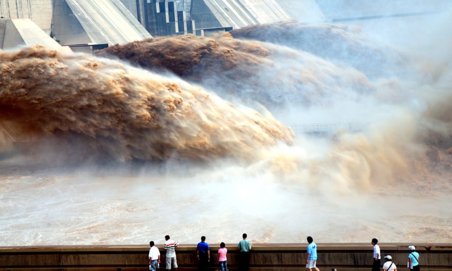 Tourists watch floodwaters gushing out of the Xiaolangdi Dam during a flood-discharge and sand-washing operation on the Yellow river.