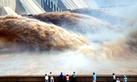 Tourists watch floodwaters gushing out of the Xiaolangdi dam during a sand-washing operation of the Yellow river in Jiyuan, China, 2010. 