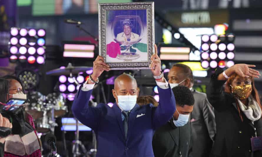 Eric Adams sostiene un retrato enmarcado de su madre que juró como alcaldesa de Nueva York en Times Square.