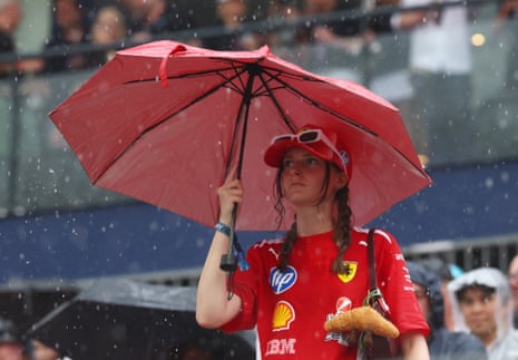 A Ferrari fan is protected from the rain in Singapore.