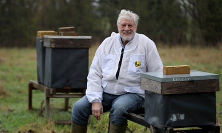 Patrick Murfet sits among some of his hives in an orchard near Canterbury in Kent