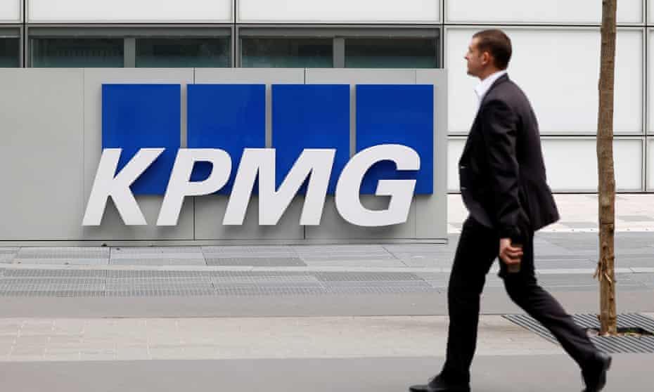 Man walks by a KPMG sign