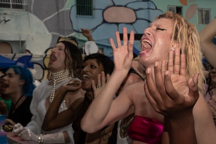 From right, Legendary Vini Ventania, Madah Sodré and Legendary Vitória Jovem cheer on friends from Rio de Janeiro’s ballroom community as they perform on stage during the Transconexão Ball at Espaço Lazer in Parque União, Maré. The ball was part of the 15th Maré LGBTI+ Pride celebrations.
