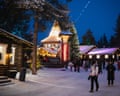 Tourists walk around Santa Claus Village in the dark