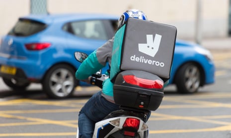A Deliveroo rider on a moped making a food delivery