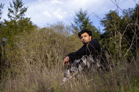 A man sits for a portrait in tall grass