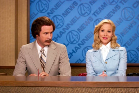 Actors Will Ferrell and Christina Applegate sitting next together behind a desk in the film Anchorman, 2003