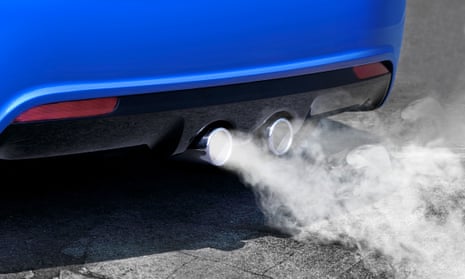 Exhaust is seen coming out of twin exhaust pipes on a car