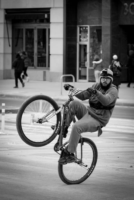 Man does a wheelie on a bicycle.
