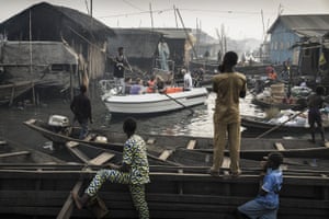 The picture shows a boat with tourists from Lagos Marina, steered through the canals of the Makoko community - an ancient fishing village that has grown into an enormous informal settlement on the shores of Lagos lagoon.