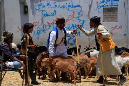 men negotiate over animals outside