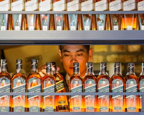 A bartender takes a bottle of Johnnie Walker whisky at a bar in Almaty, Kazakhstan.