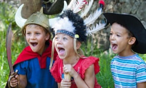 Three children in fancy dress playing.