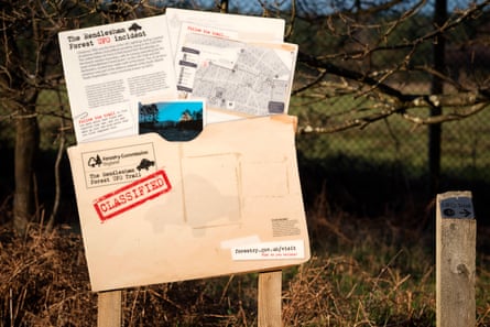 A wooden sign styled to look like a classified folder with documents appearing from the top