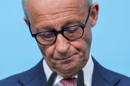 Friedrich Merz looks down with a sad expression.