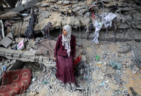 A Palestinian woman sits amid the damage at an Unrwa school sheltering displaced people that was hit in an Israeli airstrike in Gaza City.