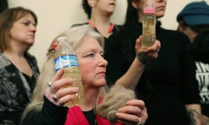 Flint residents hold bottles of contaminated water after attending a House Oversight and Government Reform Committee hearing on the water crisis.
