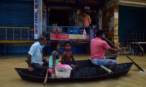 People living along the Shilabati River in Bengal, India, navigate their town by boat after heavy rains flooded the streets. 