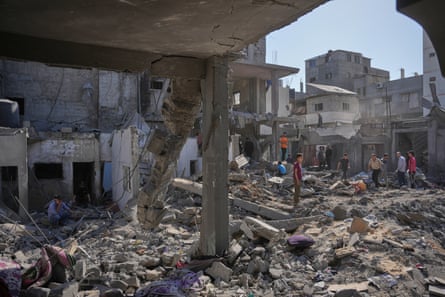 Palestinians inspecting the rubble of a building