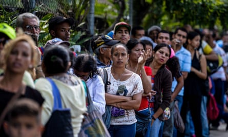 People queue outside a supermarket in Caracas.