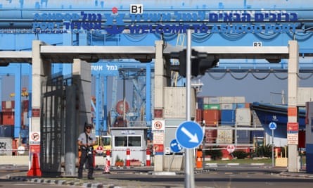 Armed men stand at the entrance to a port 