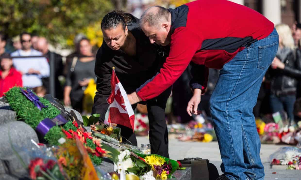 People place flowers in remembrance of Cpl Nathan Cirillo after he was killed by a gunman in Ottawa.