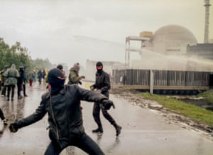 Demonstrators hurl rocks towards police water cannons near a nuclear power plant in Brokdorf, Germany