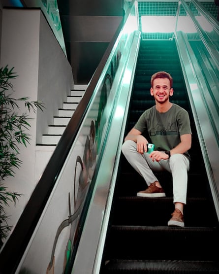 Yousef smiling while sitting on the shopping centre escalator