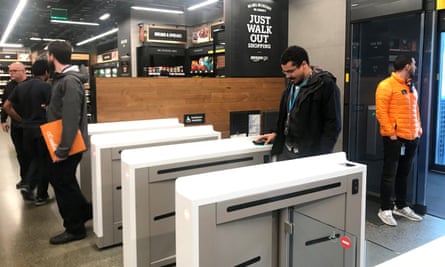 A shopper scans a smartphone app associated with his Amazon account and credit card information to enter the Amazon Go store in Seattle.