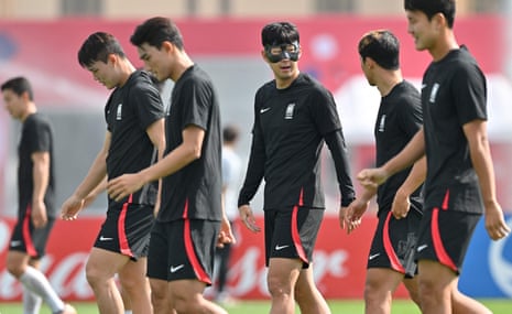 South Korea’s midfielder Son Heung-min (C) talks with teammates.