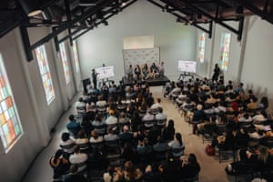overhead view of people seated in rows next to colorful windows
