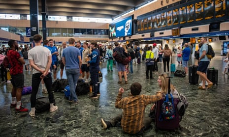 Rail passengers wait for announcements at Euston train station on July 30, 2022 in London