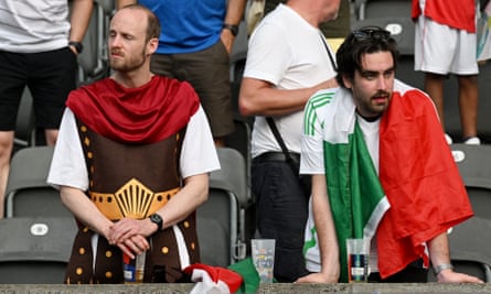 Two Italy fans look dejected after the loss to Switzerland in Berlin on 29 June 2024.
