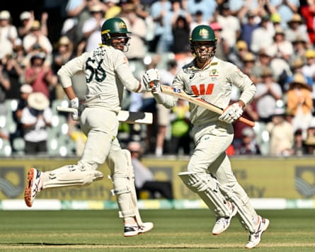 Alex Carey runs between the wickets on his way to scoring a century with Mitchell Starc