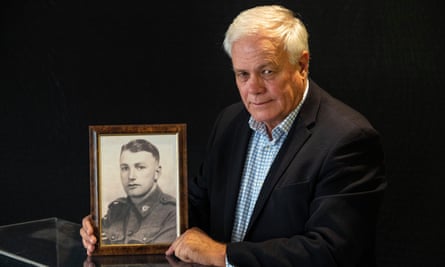 Angus Callander with a photo of his father, Lance corporal John Callander, who survived the HMAS Armidale sinking