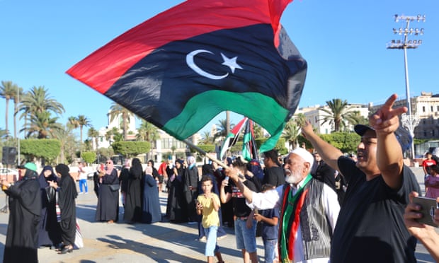 A man carries the flag of Libya during a protest in Tripoli against the president of Egypt, Abdel-Fatah Al-Sisi.