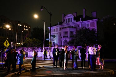 Attendees check their phones as they leave the Washington Hilton after shots were heard during the White House Correspondents’ Dinner in Washington, DC, on 25 April, 2026.