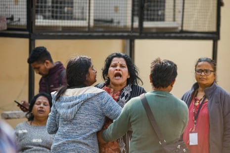 Relatives react outside a hospital mortuary in Prayagraj.