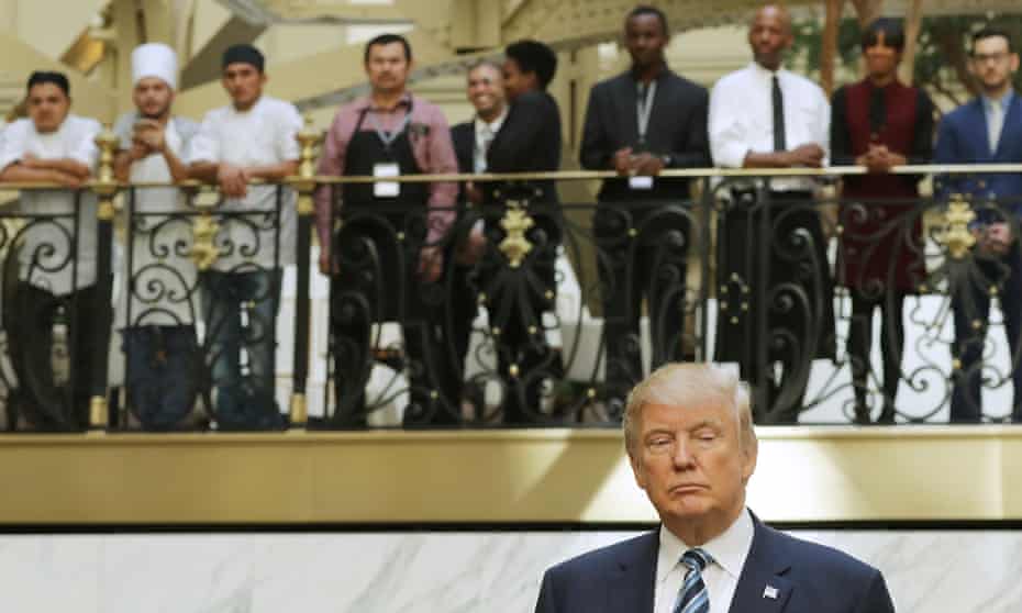 Hotel employees watch the Republican presidential nominee, Donald Trump, following a ribbon cutting ceremony at the new Trump International Hotel in Washington DC on Wednesday.