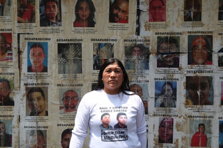 Leticia Chavez Angeles, who is searching for her two young sons, stands infront of posters of the disappered at a march on Paseo de la Reforma last month.