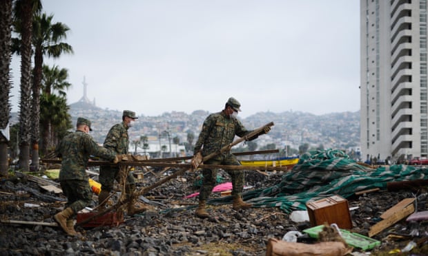 Chilean soldiers clean the debris left by the tsunami.