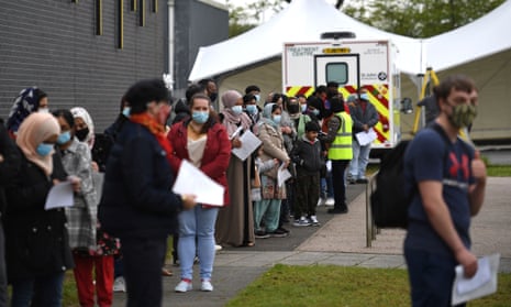 Members of the public queue at a temporary Covid-19 vaccination centre in Bolton on 14 May.