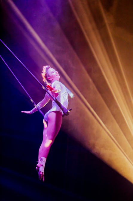 an acrobat swings on a trapeze