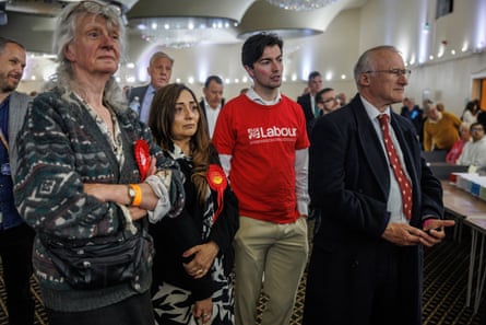Labour members stand in a crowded hall