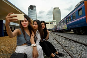 Posing for selfies next to a train.