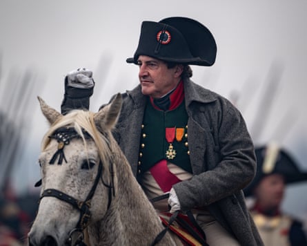 An actor dressed as Napoleon Bonaparte on a white horse.