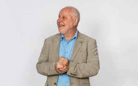 Peter with his hands clasped together in front of a white backdrop