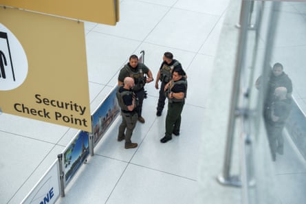 Federal agents stand in near an airport security checkpoint